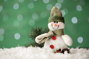 Snowman toy and Christmas decor on snow against blurred festive lights, closeup. Space for text