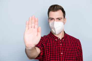 Photo portrait of man with extended arm showing palm wearing white respiratory face mask isolated...