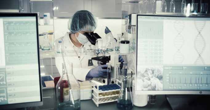 Asian Female Doctor Working With Biohazardous Samples. Using Microscope In Futuristic Laboratory