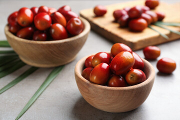 Palm oil fruits in bowl on grey table, closeup