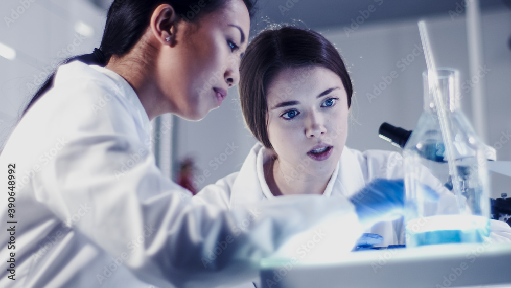 Wall mural modern laboratory. female scientists working with microscope. testing biohazardous samples