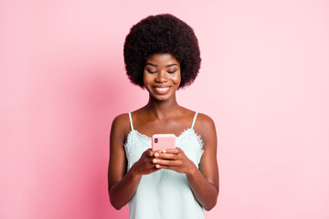 Photo of beautiful brown curly haired girl hold look phone addicted user wear singlet isolated on pink color background