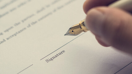 A hand signing a letter. Hand . Signing a document. Vintage style.