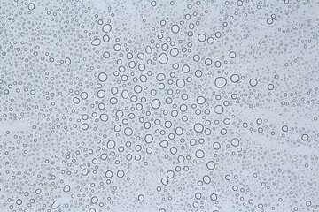Rain drops on the glass. Abstract background photo.  Natural pattern. Water drops on transparent acrylic  window sheet. 