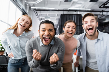 Cheerful multiethnic businesspeople looking at camera in office