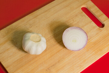 Onion and garlic on a cutting board close-up.