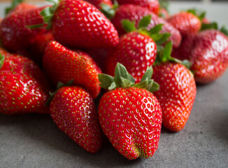 Fresh strawberries on dark grey table. Close up photo of juicy berries. Healthy eating concept. 