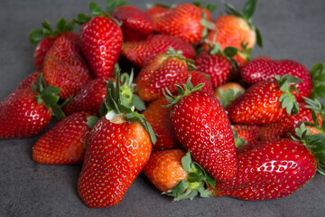 Fresh strawberries on dark grey table. Close up photo of juicy berries. Healthy eating concept. 