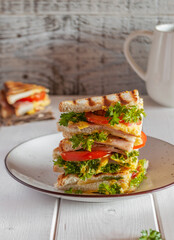 Sandwich with sauce, ham, tomatoes, herbs on a light background