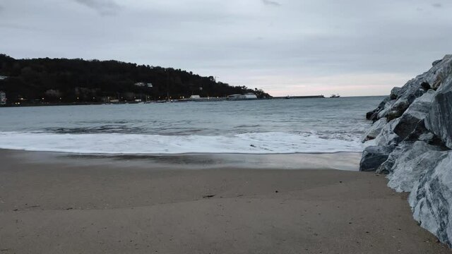 orilla de la playa de Hondarribia en un tiempo nublado. Olas y viento moviendose.