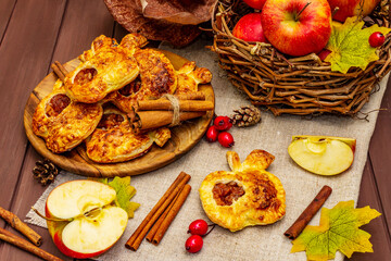 Homemade apple dessert, portioned puffs with fragrant cinnamon sticks, colorful foliage, autumn good mood