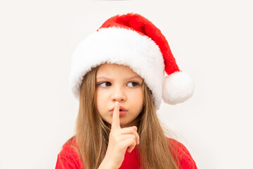 A girl in a new year's hat shows a hush sign.