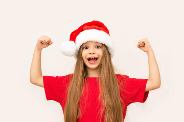 A little girl in a Christmas hat shows her strength.