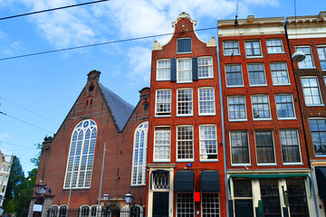 Facades of traditional houses near old church in Amsterdam, The Netherlands