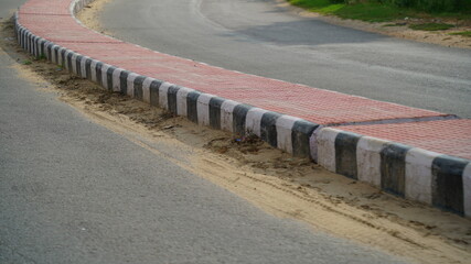 Pink color road divider in a countryside road in India. road with traffic lane dividers and barriers to facilitate traffic.