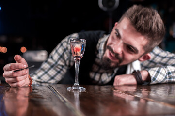 Young bartender demonstrates his professional skills in the bar