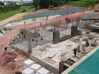 SHAH ALAM, MALAYSIA -MARCH 23, 2020: Construction workers fabricating steel reinforcement bar at the construction site. They tied it together using the tiny wires before cover it up timber formwork. 