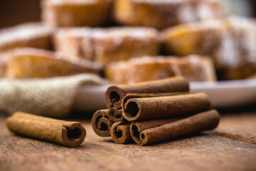 cinnamon stick on rustic table with sweet toast in the background