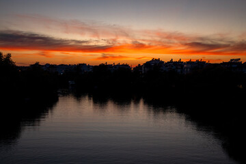 Sunset with Trees and City Silhouettes Against A Beautifully Colored Sky At River Manavgat 