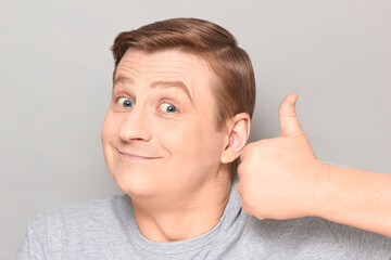 Portrait of funny happy mature man raising thumb up