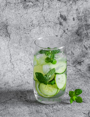 Refreshing cucumber, lime, mint water on a gray background. Summer cold drink, water sassi
