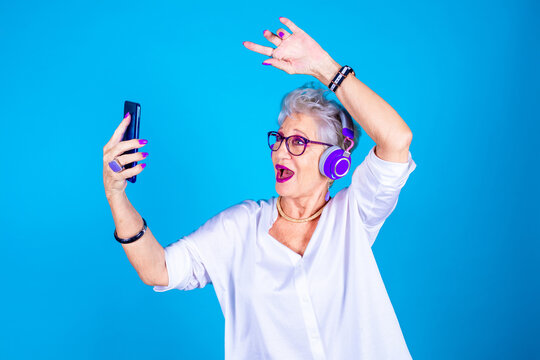 Old Woman Enthusiastic Dancing Listening Music Holding Smartphone Doing Live Streaming On Social Media