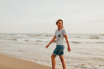 Fototapeta na wymiar woman walking at the beach looking back