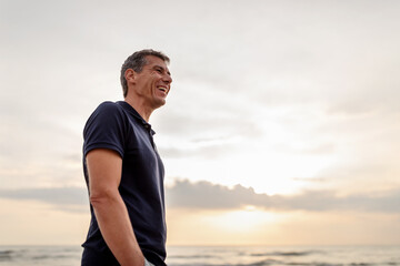 man standing at the beach looking into the distance