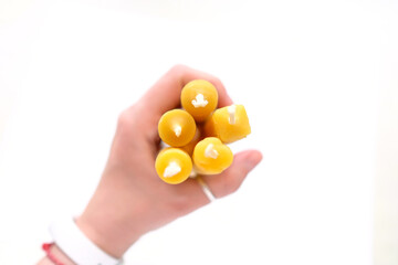 Hold several large candles in your left hand. Blurred edges, on white