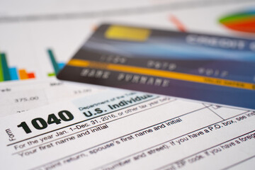Obraz premium Tax Return form 1040 with credit card on graph, U.S. Individual Income.