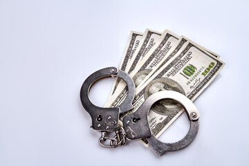 Handcuffs and money isolated on white. Crime and bribery concept.