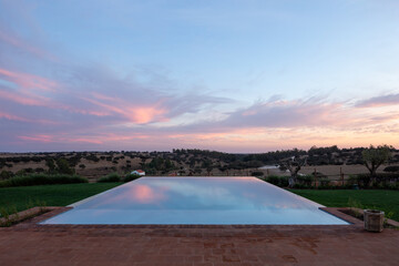 Infinity pool on the countryside at sunset