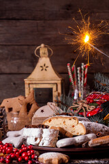 Traditional Christmas New Year dresden cake stollen with candied fruits and almonds. Christmas New Year ornament decoration. Rustic wooden background.