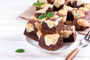 Fototapeta na wymiar Chocolate spongy brownie cakes with cookies - Brookies in a white plate. Trend dessert