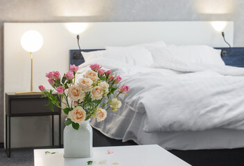 roses in vase on background bed in modern bedroom
