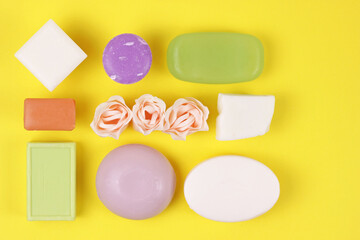 Hygiene and prevention of viral diseases concept.Variety of colorful natural soap bars on a yellow background. Top view with copy space.Flat lay with beautiful handmade soaps.