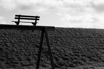 Park bench silhouette black and white facing clouds