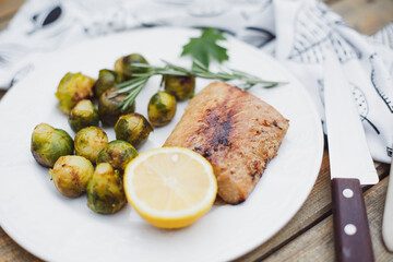 Fish baked with cheese and tomatoes, Brussels sprouts and cherry tomatoes, delicious dish, healthy food