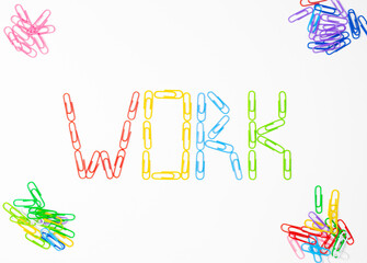 Word work.Made of colored bright paper clips on white background,top view.Close up