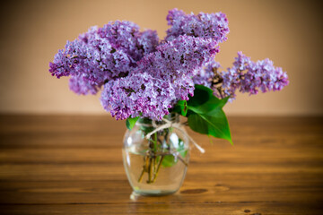bouquet of beautiful spring flowers of lilac on an orange