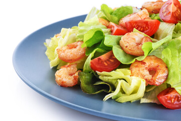 Caesar salad with shrimp lettuce and tomato on a white background.