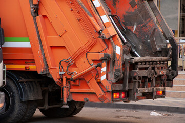 a garbage truck collects rubbish in the yards of a residential area