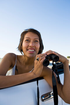 Native American woman in sun dress holding binoculars