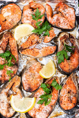 Top view. Baked chum salmon steaks with skin in the oven on foil.