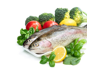 Raw fresh rainbow trout with assortment vegetables and lemons