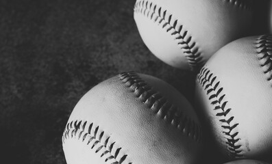 Group of baseballs close up in black and white.