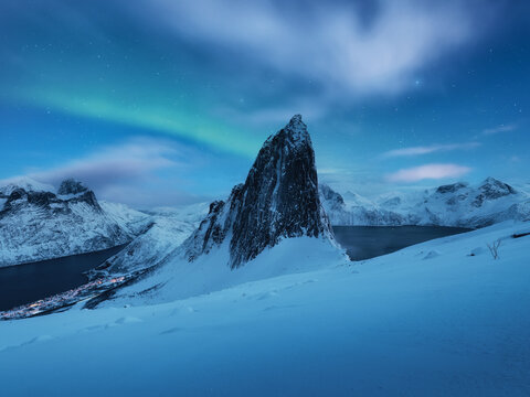 Mountain Segla and sky background with northern lights. Aurora borealis on Senja islands, Norway. Northern lights above mountains.