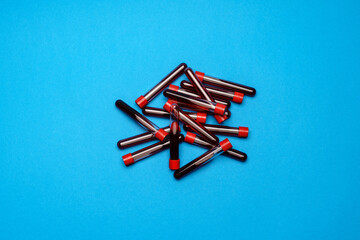 top view of medicine test tubes with blood samples over blue background