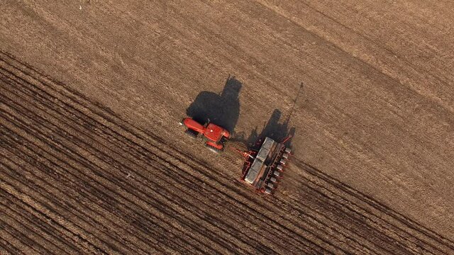 Agriculture and Agronomy. Aerial view farm tractor cuts furrows in farm field land for sowing 