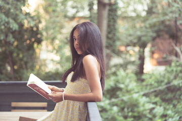 relaxed girl with a book in her hand thinking